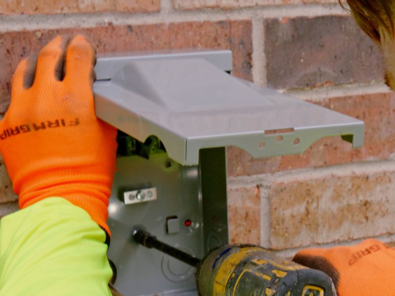 EMG technician servicing an outdoor HVAC disconnect